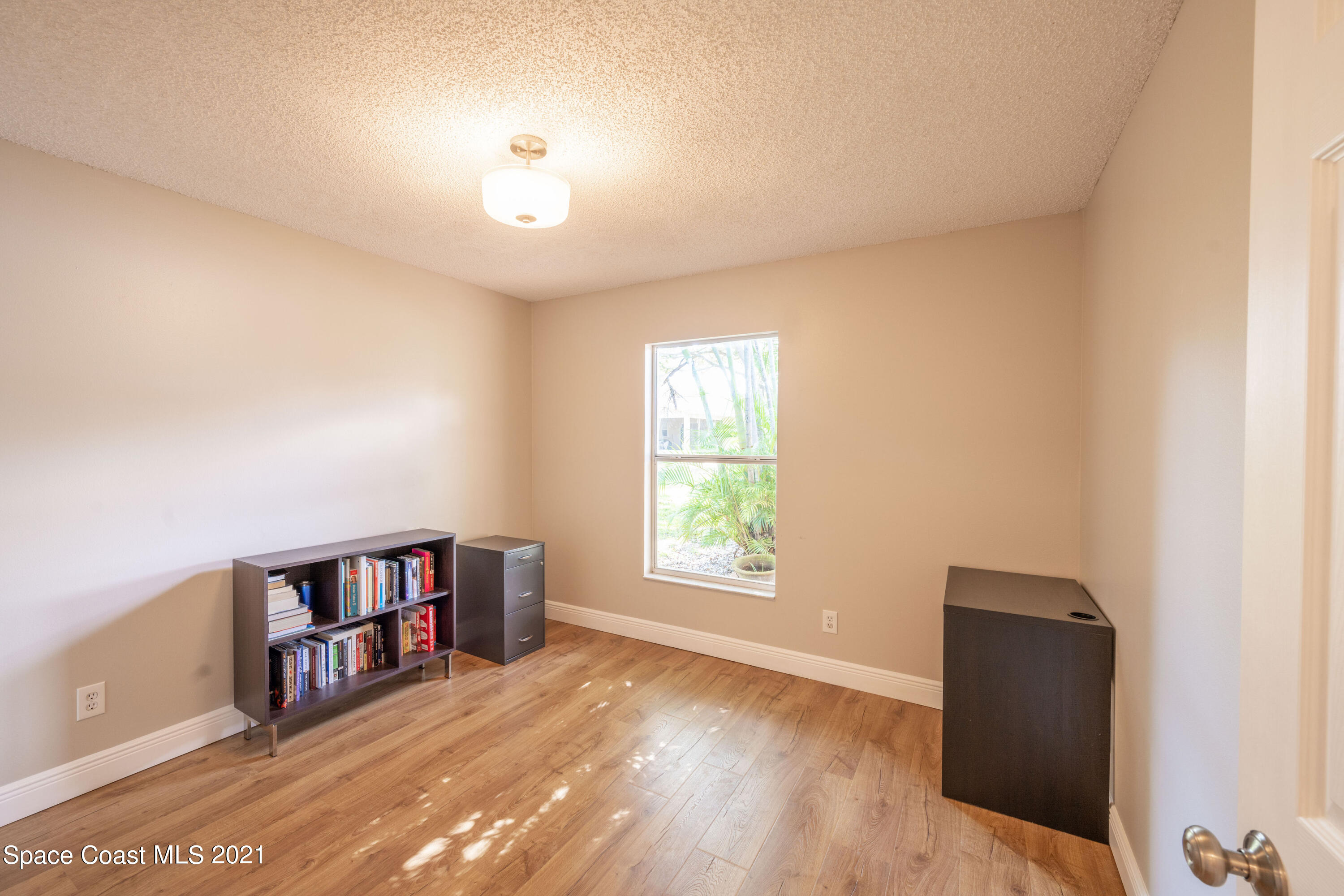 265 Oak Lake Road Melbourne, FL 32901 - Photo 13 of 25 a view of a bedroom with window and hardwood floor