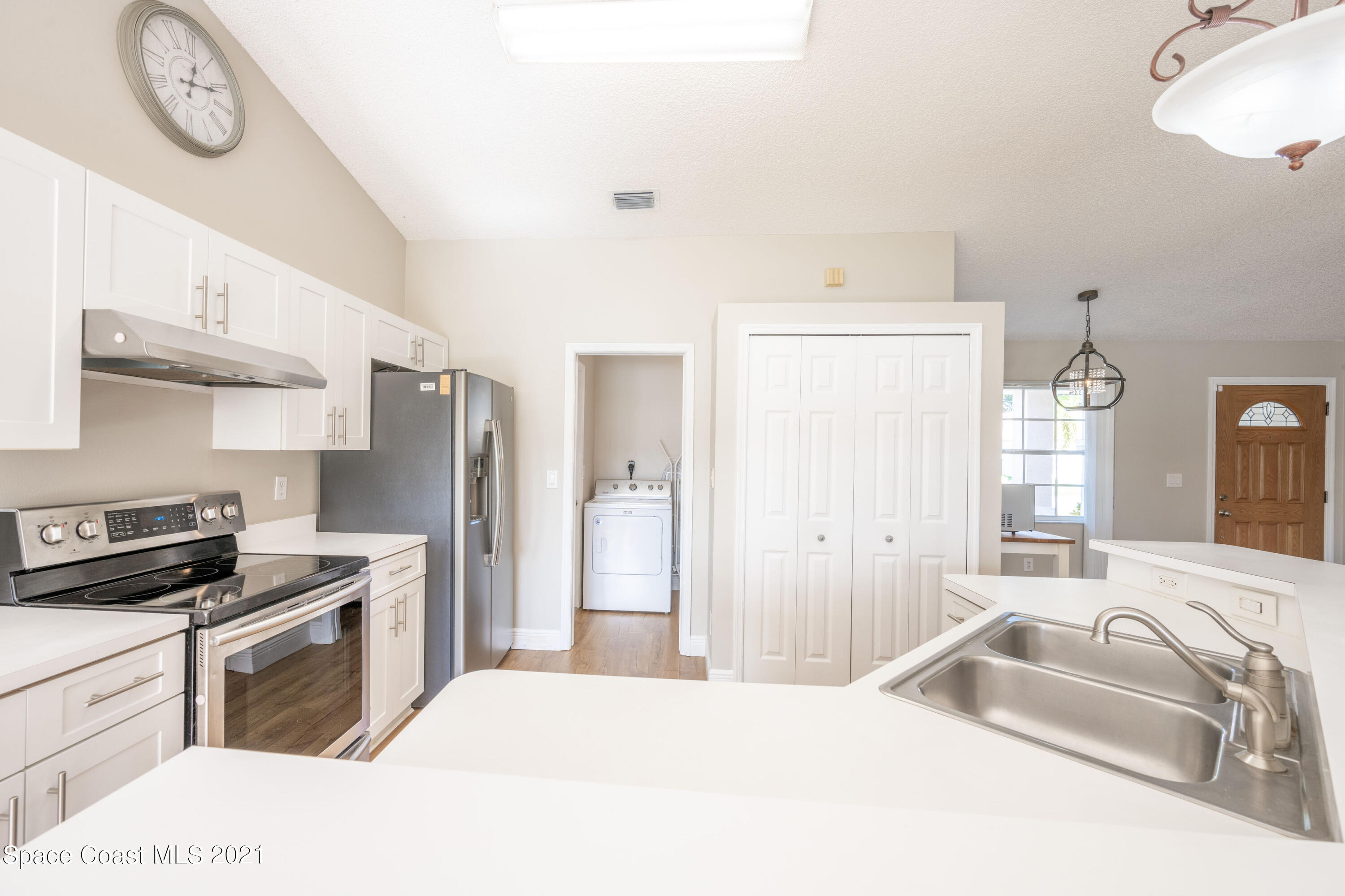 265 Oak Lake Road Melbourne, FL 32901 - Photo 4 of 25 a kitchen with a refrigerator a sink and a stove top oven