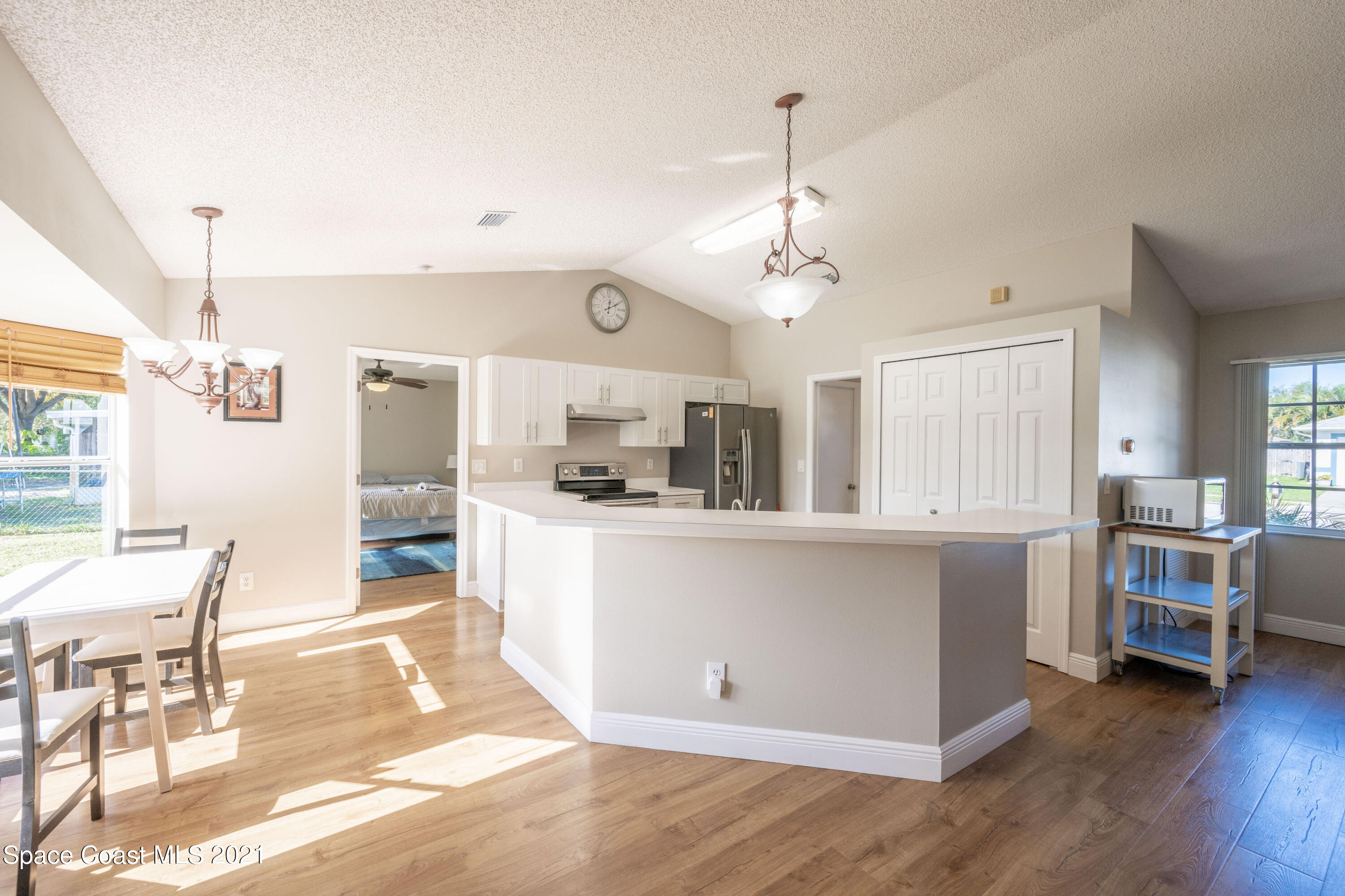 265 Oak Lake Road Melbourne, FL 32901 - Photo 5 of 25 a kitchen with stainless steel appliances kitchen island granite countertop a refrigerator a stove a sink dishwasher and white cabinets with wooden floor