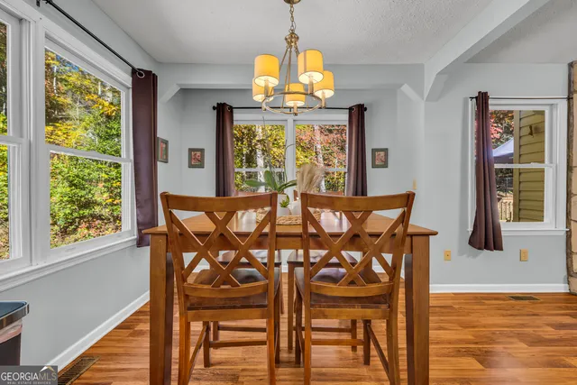 a view of a dining room with furniture a chandelier and wooden floor
