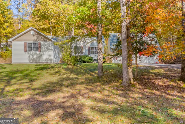 a view of a house with backyard and tree