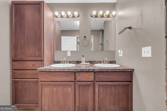 a bathroom with a granite countertop sink and a toilet
