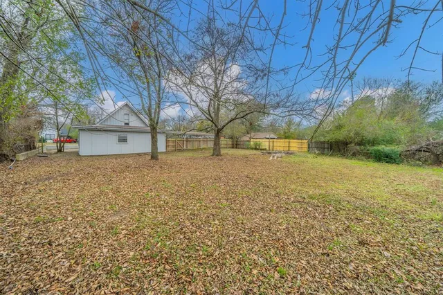 a view of a yard with a house and a large tree