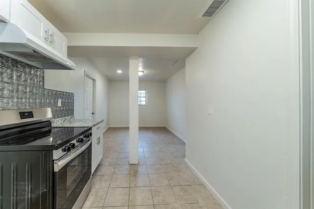 a kitchen with granite countertop a stove and cabinets