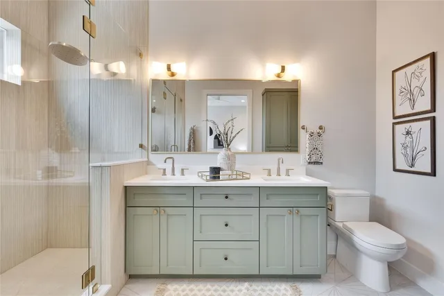 a bathroom with a double vanity sink mirror and toilet