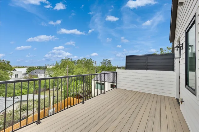 a view of a balcony with wooden floor and fence