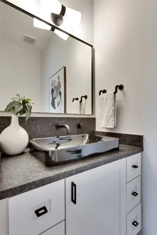 a bathroom with a granite countertop sink and a mirror