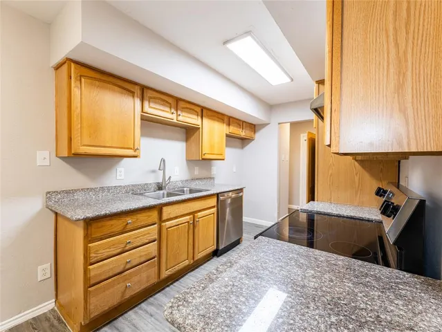 a kitchen with granite countertop a sink and a wooden cabinets