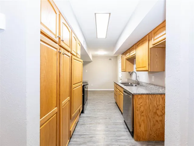 a kitchen with granite countertop a sink and a refrigerator