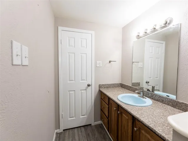 a bathroom with a granite countertop sink and a mirror