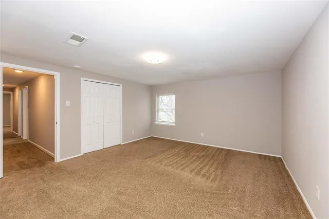 an empty room with windows and closet