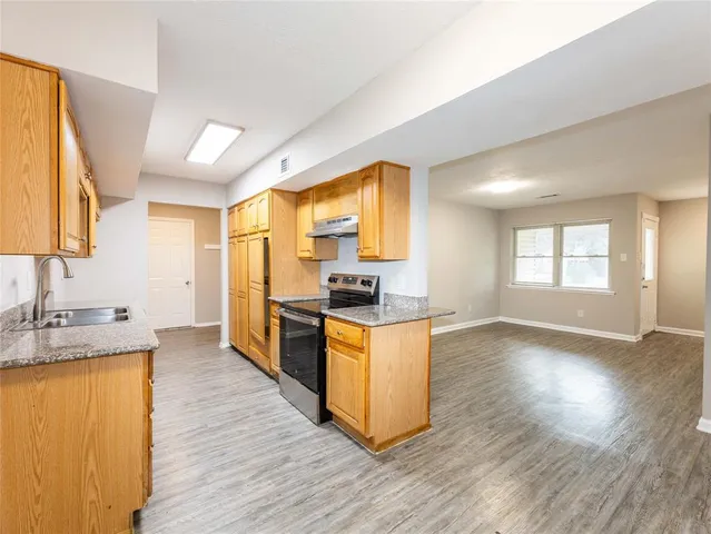 a kitchen with granite countertop wooden floors and wide window