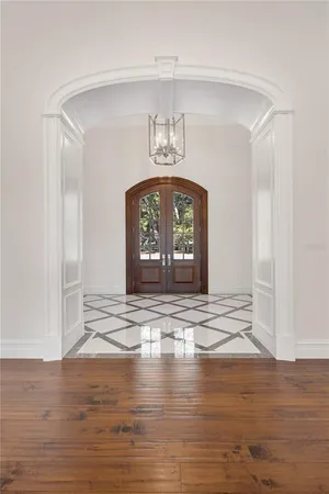 a view of an empty room with wooden floor and a fireplace