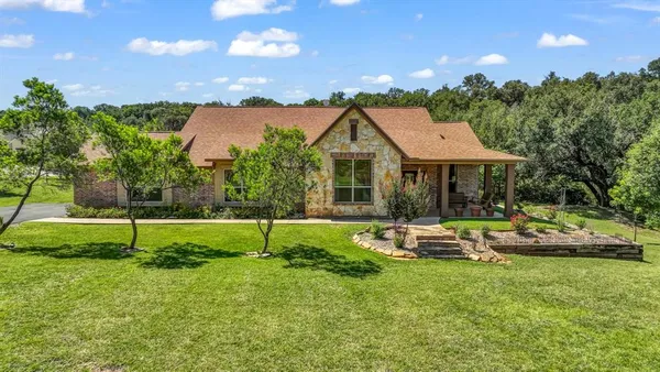 a view of house with backyard and outdoor seating