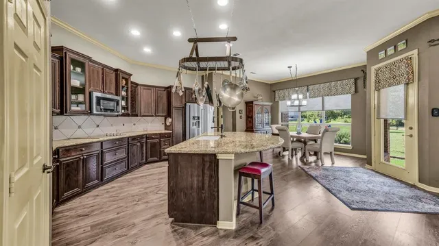 a kitchen with stainless steel appliances granite countertop a refrigerator and a stove top oven
