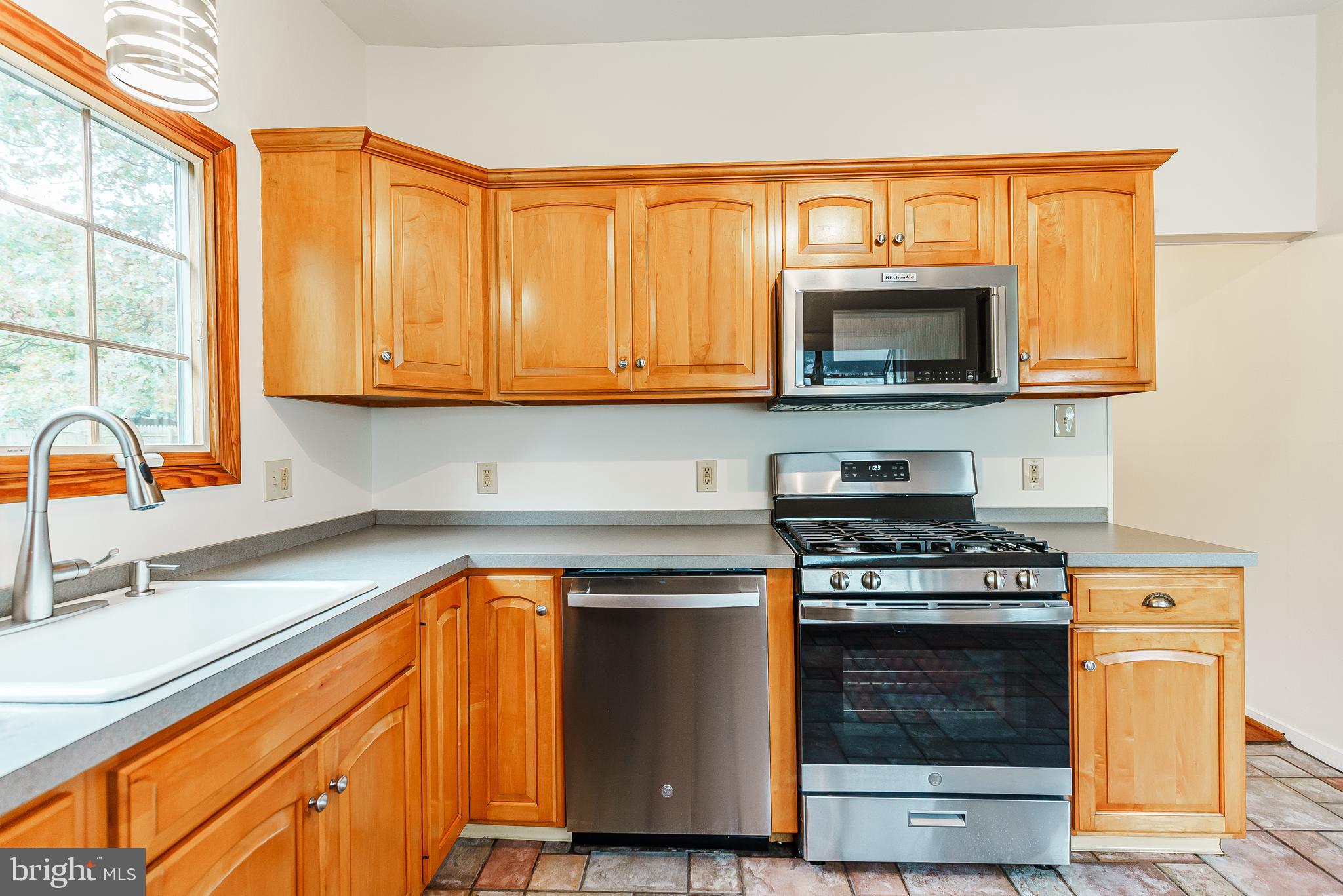 548 Paddock Road Ambler, PA 19002 - Photo 6 of 15 a kitchen with granite countertop wooden cabinets and a stove top oven
