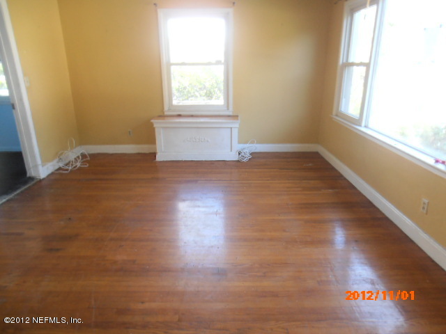 1748 Mayfair Road Jacksonville, FL 32207 - Photo 3 of 8 an empty room with wooden floor and windows