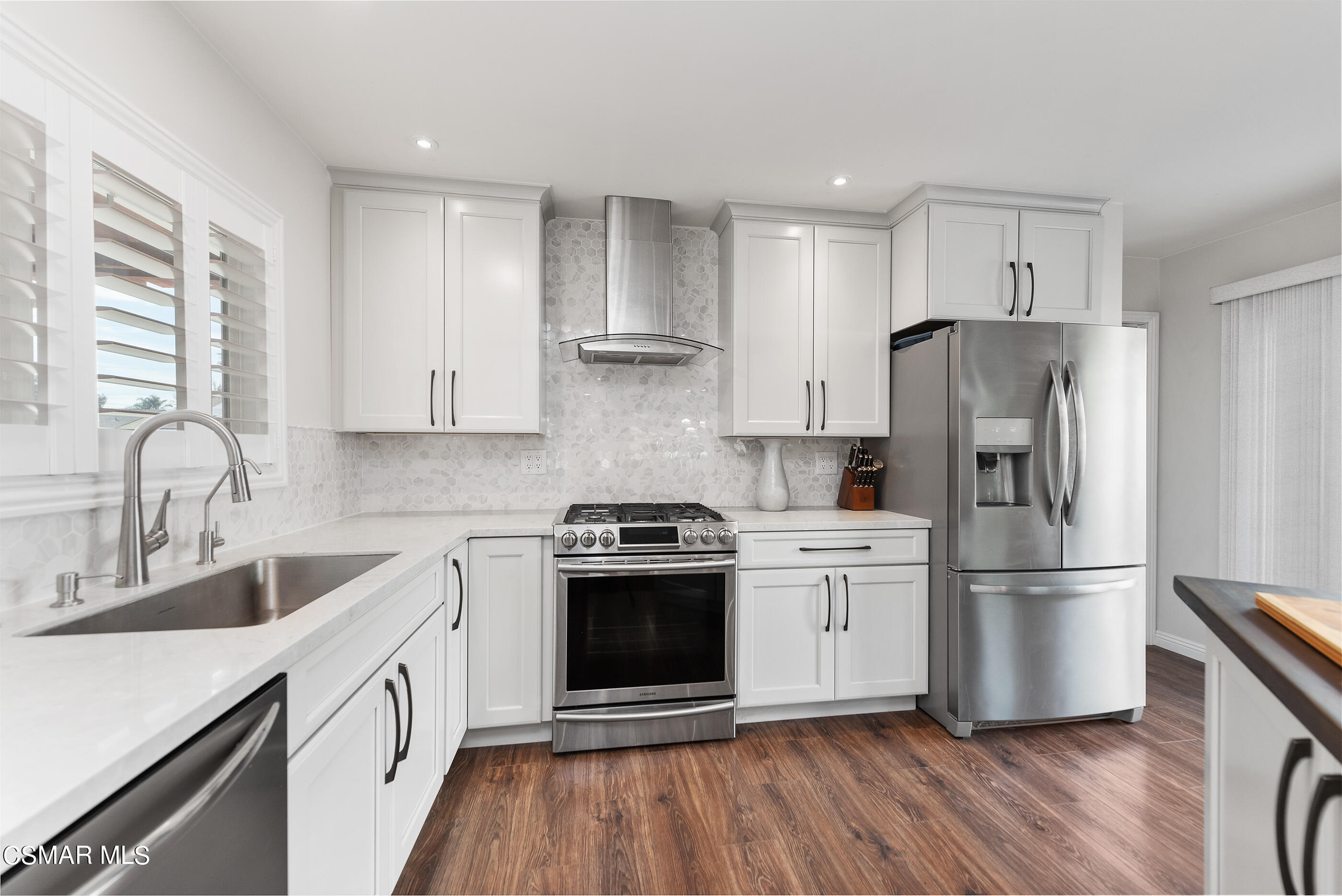 2066 Hurles Avenue Simi Valley, CA 93063 - Photo 22 of 50 a kitchen with white cabinets stainless steel appliances and wooden floor