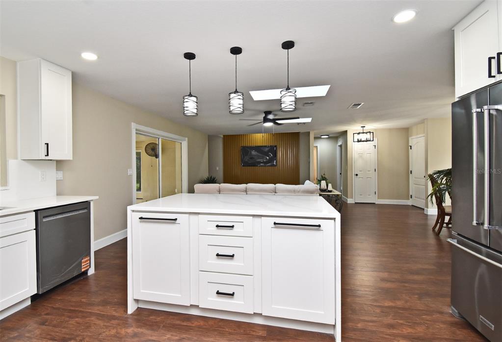 1444 Bird Road Casselberry, FL 32707 - Photo 18 of 70 a view of a kitchen island stainless steel appliances wooden floor and living room view