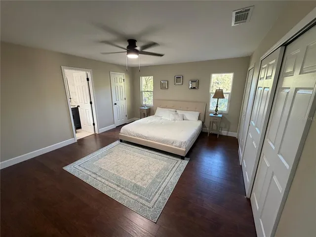 a view of a big room with wooden floor and windows