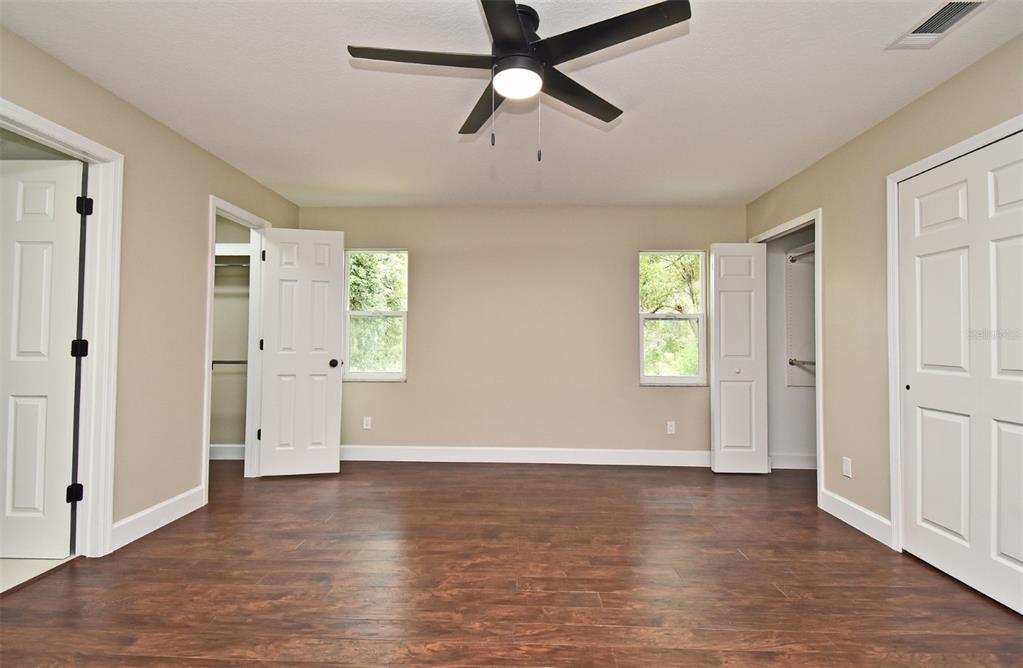 1444 Bird Road Casselberry, FL 32707 - Photo 21 of 70 an empty room with wooden floor a ceiling fan and windows