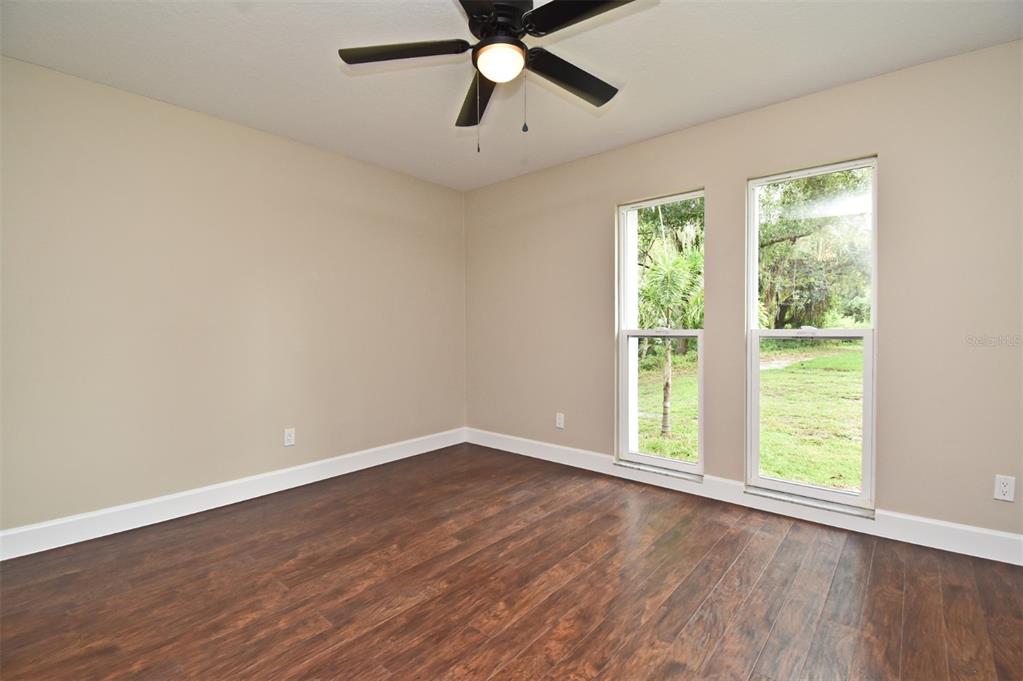 1444 Bird Road Casselberry, FL 32707 - Photo 29 of 70 an empty room with wooden floor fan and windows