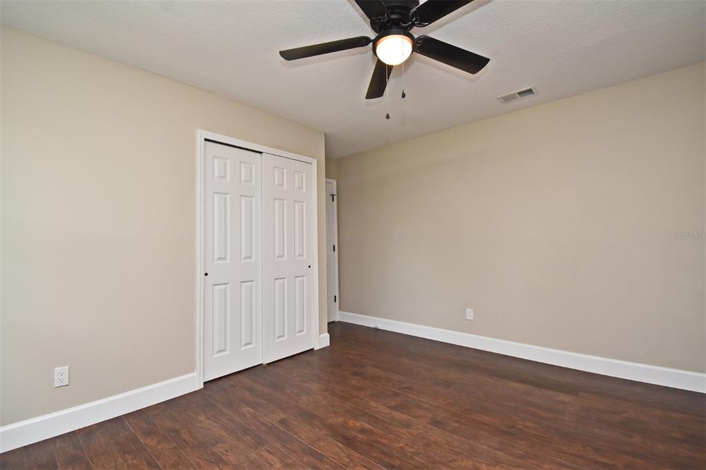 1444 Bird Road Casselberry, FL 32707 - Photo 32 of 70 an empty room with wooden floor ceiling fan and window