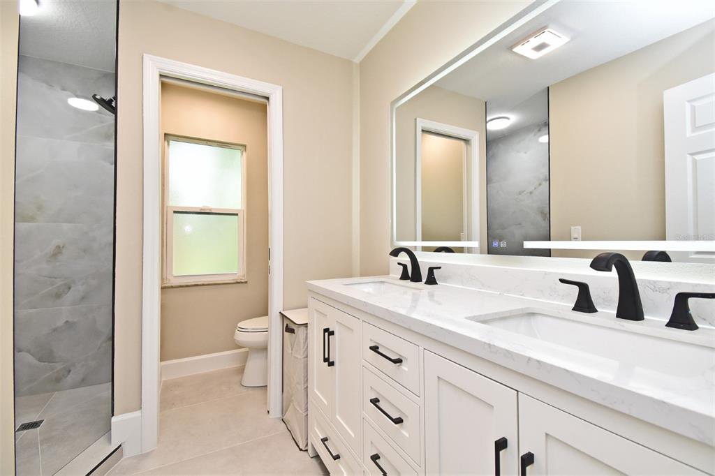 1444 Bird Road Casselberry, FL 32707 - Photo 36 of 70 a bathroom with a double vanity sink toilet and shower