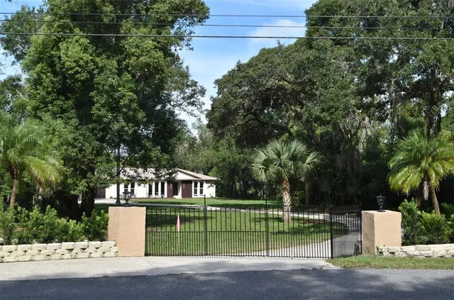 a front view of a house with a garden and trees