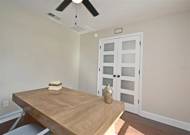 a spacious bedroom with a bed and a dresser with wooden floor