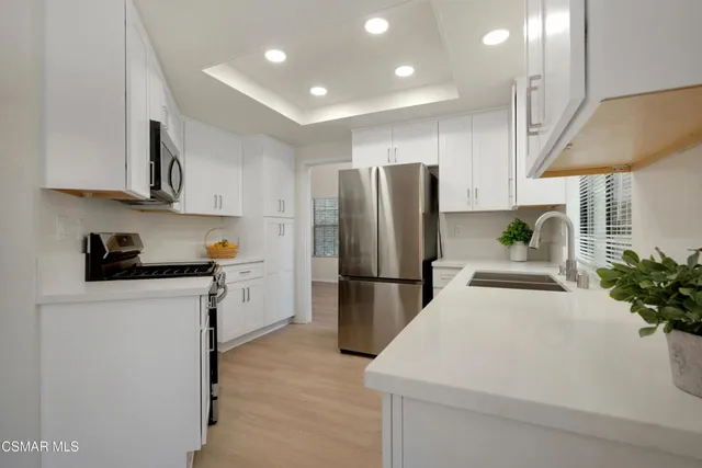 a kitchen with stainless steel appliances a refrigerator sink and cabinets