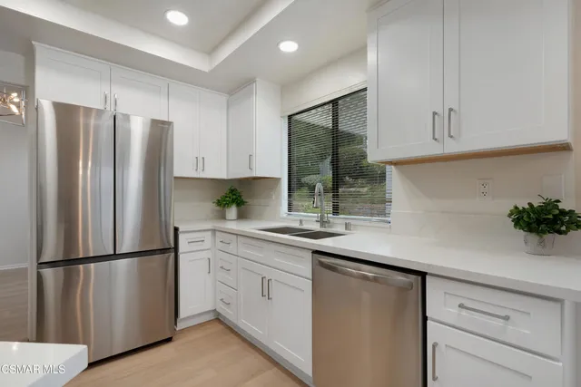a kitchen with stainless steel appliances a refrigerator sink and cabinets