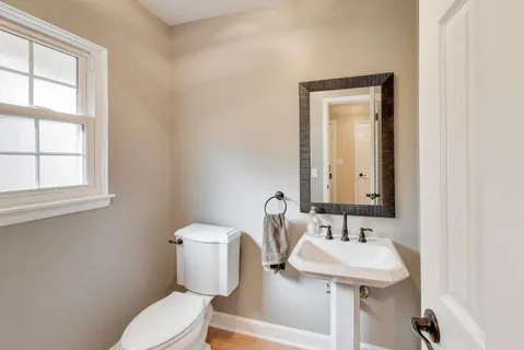 a bathroom with a toilet sink and mirror