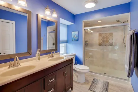 a bathroom with a double vanity sink toilet and shower