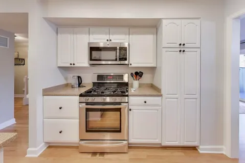 a kitchen with stainless steel appliances white cabinets and a sink