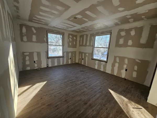 a view of a hallway with wooden floor and stairs