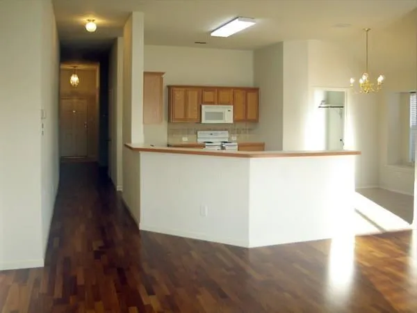 a view of a kitchen with wooden floor and a window