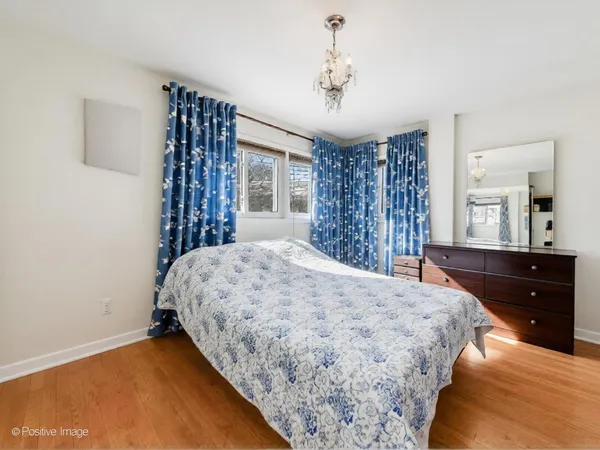 a bedroom with a large bed and a chandelier