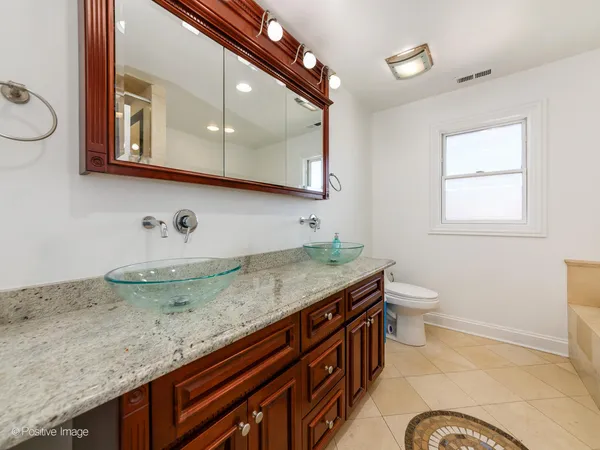 a bathroom with a granite countertop sink a toilet and mirror