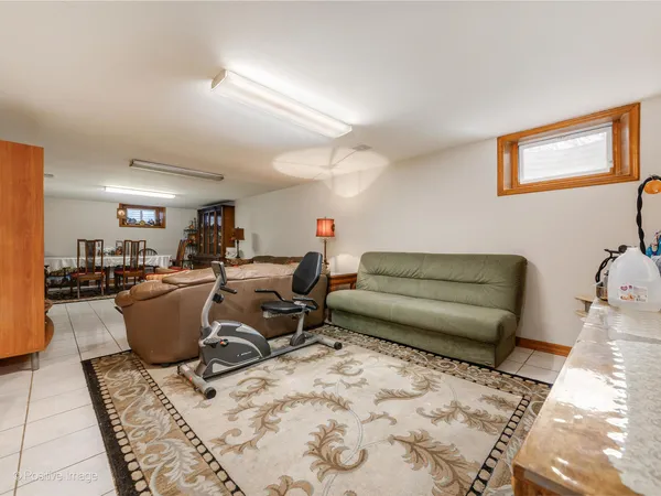 a living room with a couch and potted plant with wooden floor