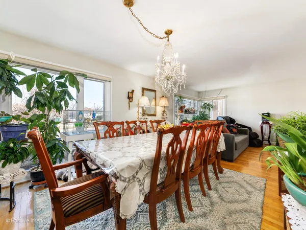 a living room with furniture a chandelier and a dining table