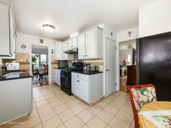 a kitchen with white cabinets and appliances