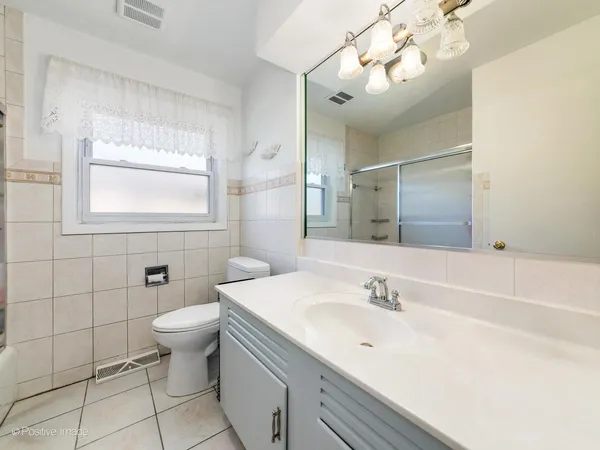 a bathroom with a sink a toilet and mirror