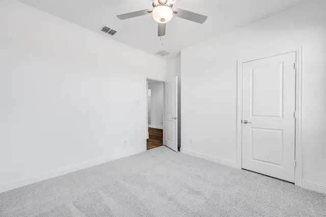 a view of an empty room with a chandelier fan