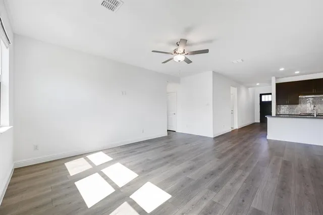 a view of empty room with wooden floor and window