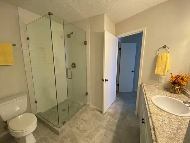 a bathroom with a granite countertop sink toilet and shower