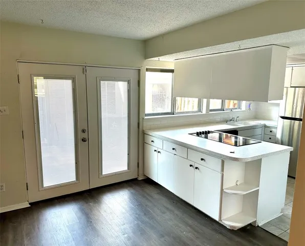 a view of a kitchen with wooden floor and electronic appliances