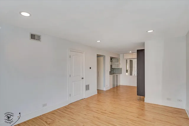 a view of an empty room with wooden floor