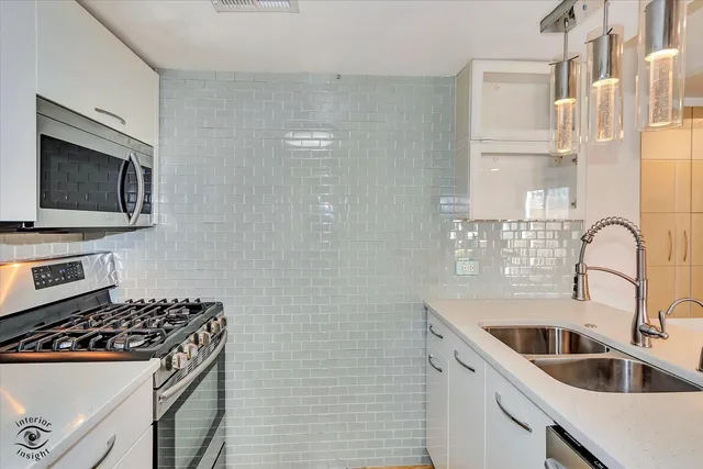 a kitchen with a sink stove top oven and refrigerator