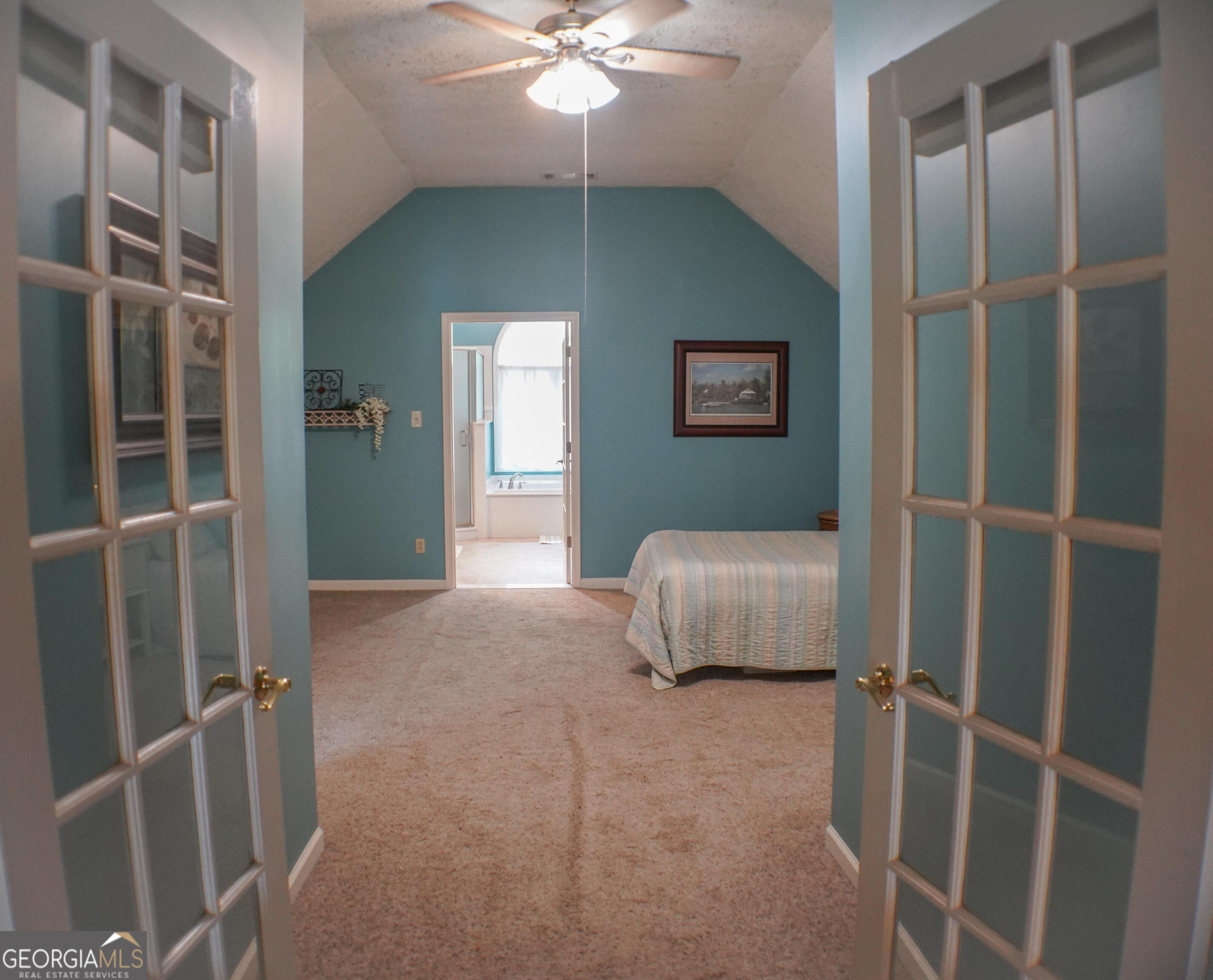 335 Winding Stream Trail Hampton, GA 30228 - Photo 19 of 35 a bedroom with a bed and a chandelier